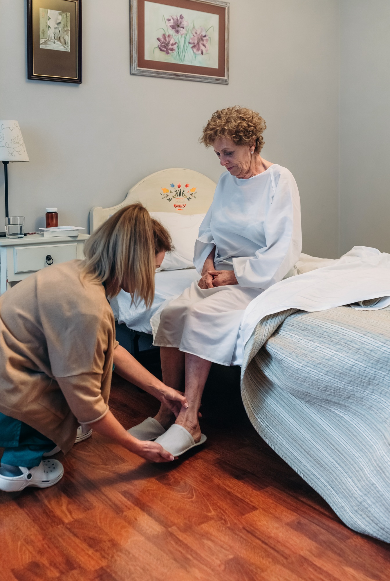 Carer wearing slippers to elderly patient